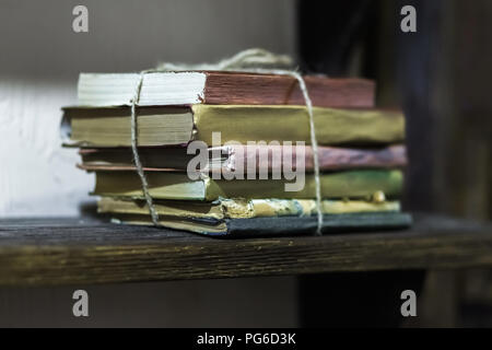 Stack of old books with golden covers on the shelf Stock Photo