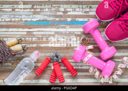 Body Care and Beauty, Weight and Dieting Healthy lifestyle concept. Sport equipment, Dumbbells, running shoes, skipping ropes on wooden background. Stock Photo