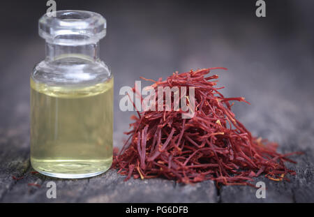 Closeup of Saffron with extract in a bottle on natural surface Stock Photo