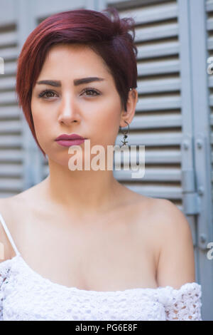 Beautiful young woman with short red hair looking away outdoors Stock Photo