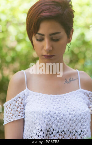 Sad woman looking down outdoors Stock Photo