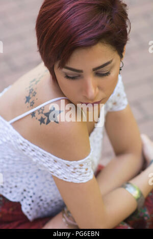 Sad woman sat outdoors Stock Photo