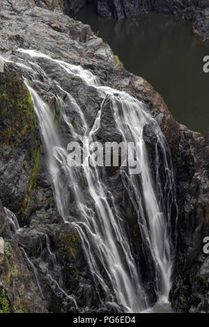 Waterfall flowing over rocks at Barron Falls Gorge Stock Photo