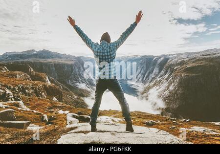 Traveler man exploring mountains alone happy raised hands adventure journey summer vacations traveling lifestyle weekend getaway Stock Photo