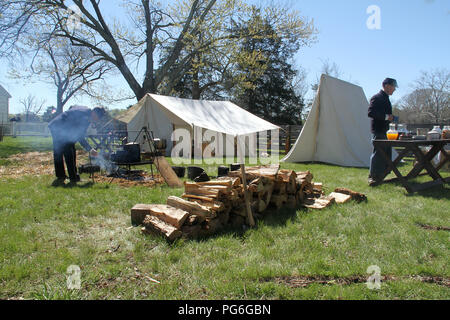 The Confederate Army camping during the American Civil War. Splitting wood and cooking over open fire. Historical reenactment at Appomattox, Virginia. Stock Photo