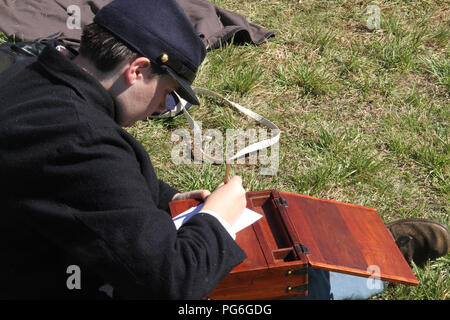 The Confederate Army camping during the American Civil War. Soldier writing a letter. Historical reenactment at Appomattox, VA, USA. Stock Photo