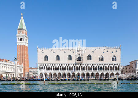 Doges Palace, Ducal Palace, Palazzo Ducale,  and St Marks Campanile, San Marco, Venice, Italy. gondolas and tourists on Riva degli Schiavoni, blue sky Stock Photo