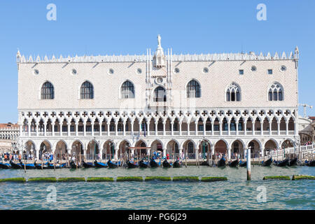 Doges Palace, Palazzo Ducale, Ducal Palace, San Marco, Venice, Veneto, Italy in morning light from the lagoon with gondolas and tourists, blue sunny s Stock Photo