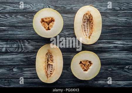top view of halved ripe sweet honeydew and cantaloupe melons on wooden surface Stock Photo