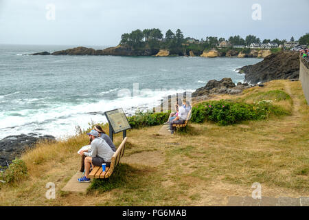 People sitting on bench and looking for whales at Depoe Bay, whale watching center, Oregon, USA Stock Photo