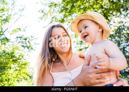 Portrait of happy woman and baby boy in nature Stock Photo