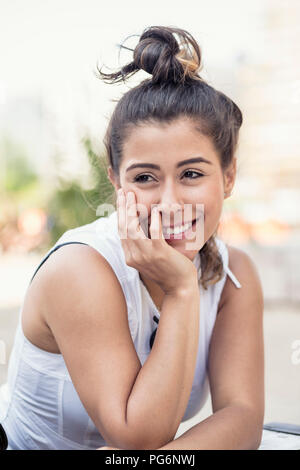 Portrait of smiling young woman with bun Stock Photo