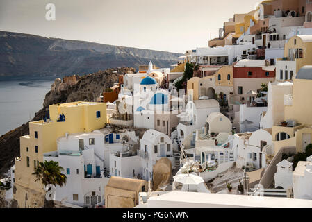 Oia blue dome churches and two story whitewashed captain's houses on Santorini Island, Greece in Cycladic style. Stock Photo