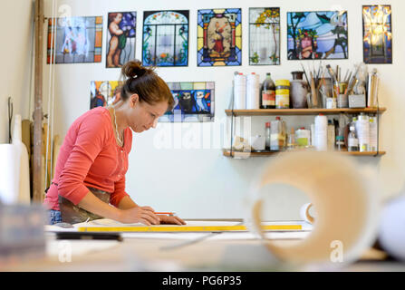 Woman working on draft in glazier's workshop Stock Photo