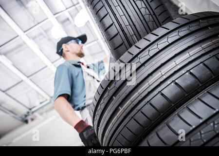 Replacing Old Car Tires. Vulcanization Service Worker and New Tires. Stock Photo