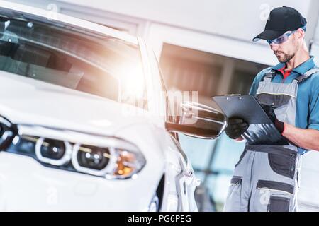 Pre Owned Vehicle Evaluation by Caucasian Car Mechanic. Automotive Concept. Stock Photo