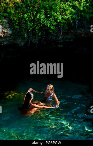 Young womanswimming in lagoon with her best friend Stock Photo