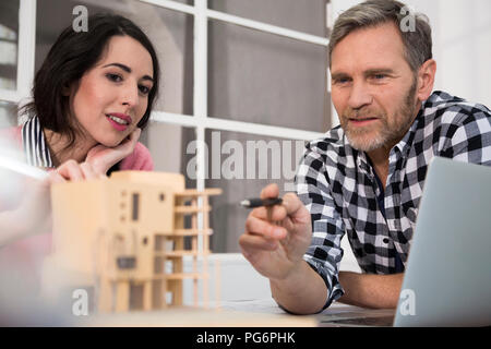 Colleagues discussing architectural model in office Stock Photo