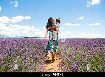 France, Provence, Valensole plateau, Mother and daughter walking among lavender fields in the summer Stock Photo