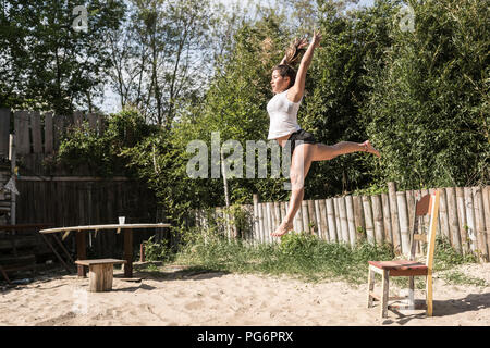 Young woman jumping in the air outdoors Stock Photo