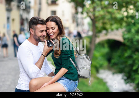 Happy tourist couple using cell phone in the city Stock Photo