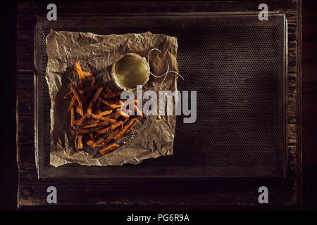 Hand made french fries with mayonnaise on baking paper, baking tray, overhead view Stock Photo