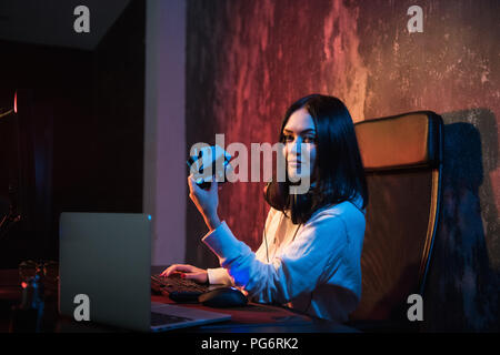 young teenager hacker girl in hoodie holding credit card violating private password holding credit card in cybercrime and cyber crime concept and internet information security concept Stock Photo