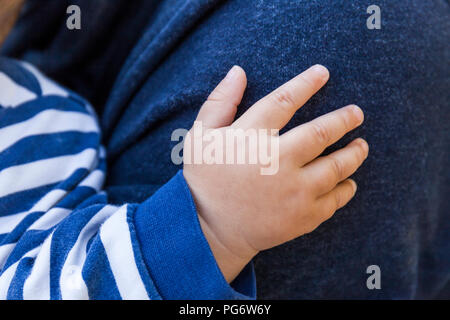 Hand of baby boy on father's shoulder, close-up Stock Photo