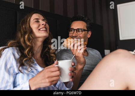 Happy couple having breakfast in bed at home Stock Photo