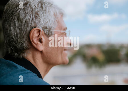 Smiling senior man with hearing aid outdoors Stock Photo