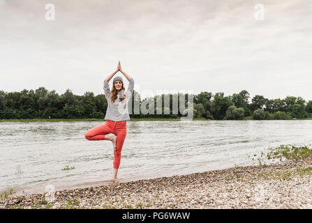 Woman practicing yoga in a river Stock Photo