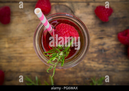 Glass bottle of homemade raspberry lemonade flavoured with rosemary Stock Photo