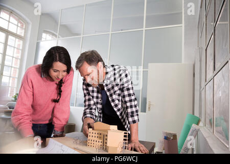 Colleagues discussing architectural model in office Stock Photo