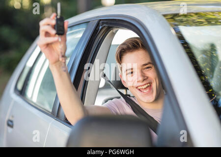 Happy learner driver cheering and holding car key Stock Photo