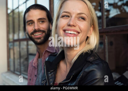 Happy young couple outdoors looking sideways Stock Photo