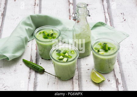 Three glasses and a bottle of homemade green Gazpacho Stock Photo
