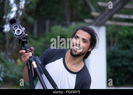 Portrait of happy young man with vintage camera Stock Photo