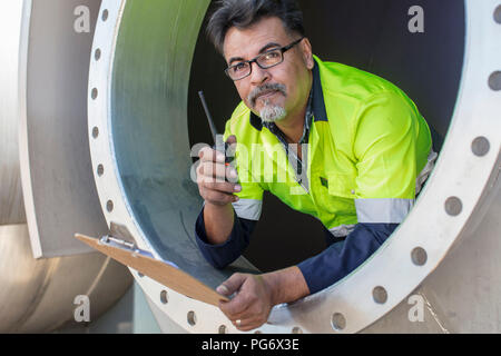 Worker in a tank using walkie talkie Stock Photo