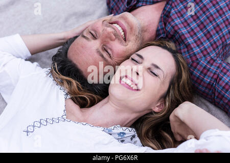 Happy affectionate couple lying on a blanket Stock Photo