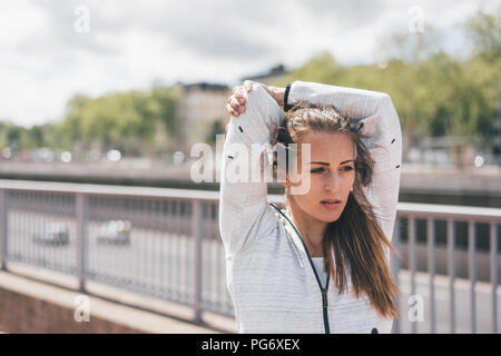 Sportive young woman stretching outdoors Stock Photo