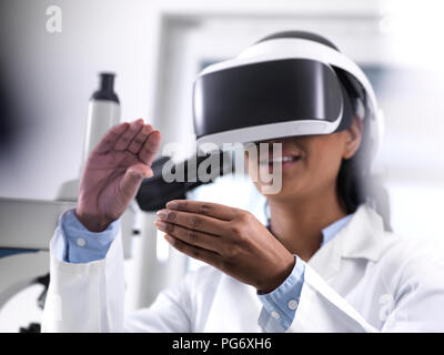 Female scientist using virtual reality to understand a research experiment in the laboratory Stock Photo