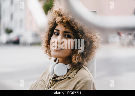 Woman in the city with headphones, portrait Stock Photo