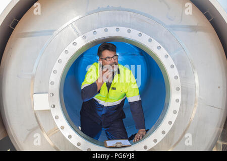 Worker in a tank using walkie talkie Stock Photo