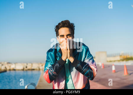 Surprised man covering his mouth with his hands Stock Photo