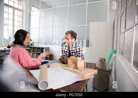 Colleagues discussing architectural model in office Stock Photo
