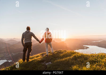 Austria, Salzkammergut, Couple standing on mountain summit, enjoying the view Stock Photo