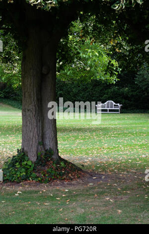 A traditionally shaped Lutyens 3 seater bench made from Cornis hardwood in a Large English country house in Nottinghamshire. Stock Photo