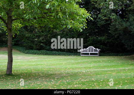 A traditionally shaped Lutyens 3 seater bench made from Cornis hardwood in a Large English country house in Nottinghamshire. Stock Photo