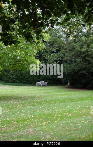 A traditionally shaped Lutyens 3 seater bench made from Cornis hardwood in a Large English country house in Nottinghamshire. Stock Photo