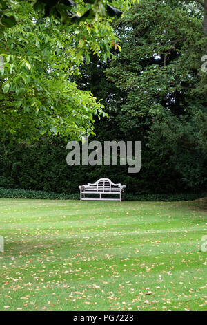 A traditionally shaped Lutyens 3 seater bench made from Cornis hardwood in a Large English country house in Nottinghamshire. Stock Photo